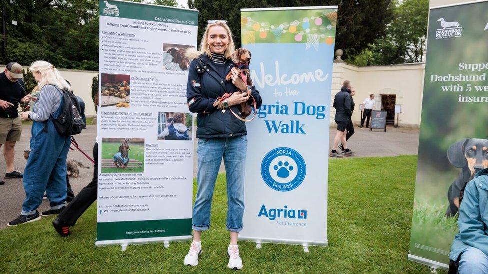 Jodie Kidd with Sausage, posing in front of marketing banners