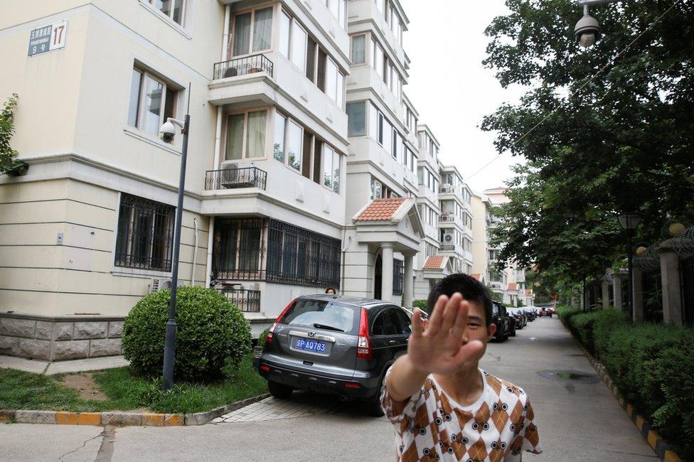 Plain clothes security personnel attempt to prevent the photographer from taking pictures of the house of Liu Xia, the wife of late dissident Liu Xiaobo in Beijing, China, 14 July 2017.