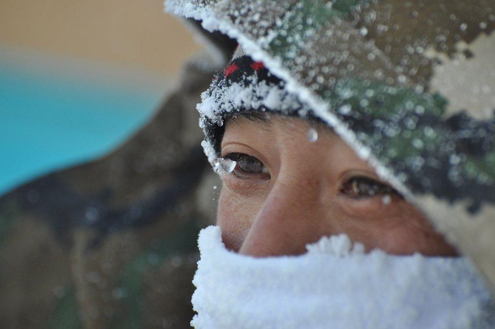 This photo taken on January 23, 2016 shows ice forming on an armed policeman's face on a street in the city of Hulun Buir, in northern China's Inner Mongolia area.