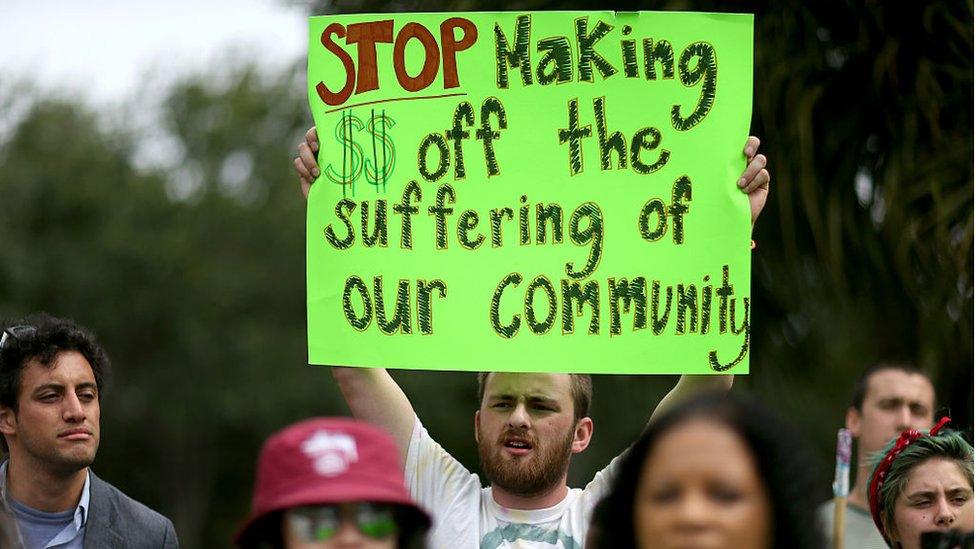 a protester pickets against private prisons