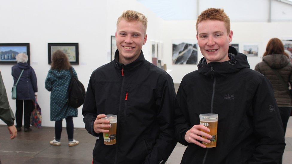 Dau ddyn ifanc gyda pheint o gwrw yn Y Lle Celf // Two young men with a pint of beer in the art gallery