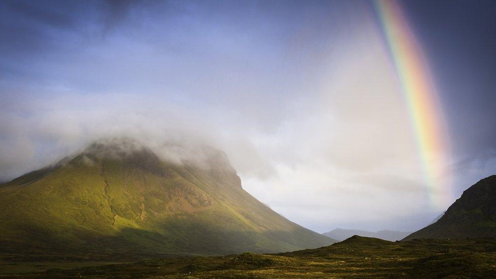 A rainbow leading up to the sky.