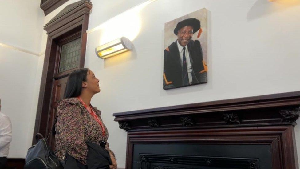 Bert Carless' granddaughter looking at his picture