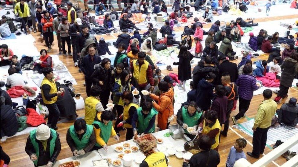 People stand in lines to get food at a stadium in Pohang, North Gyeongsang Province, South Korea, 15 November 2017 (issued 16 November 2017).