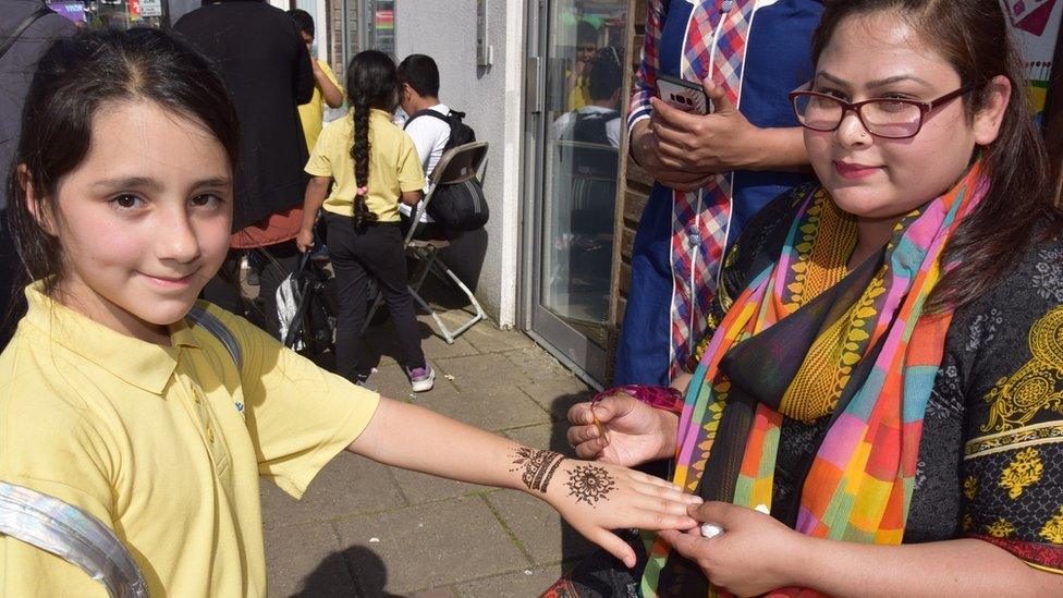 A girl getting a traditional henna tattoo on her hand