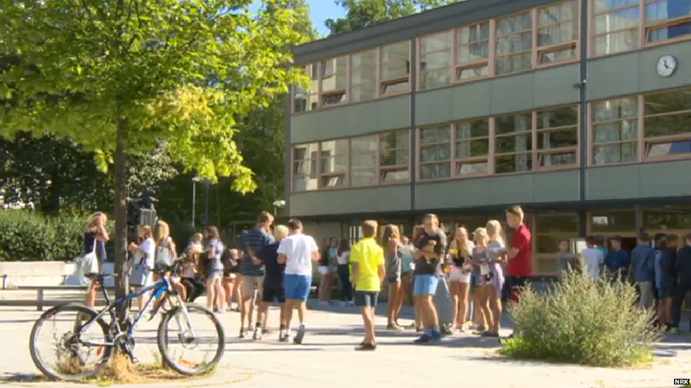 A view of Hovseter school with students chatting outside