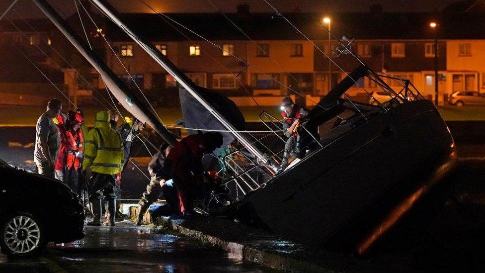 Coastguards inspecting a boat at a harbour