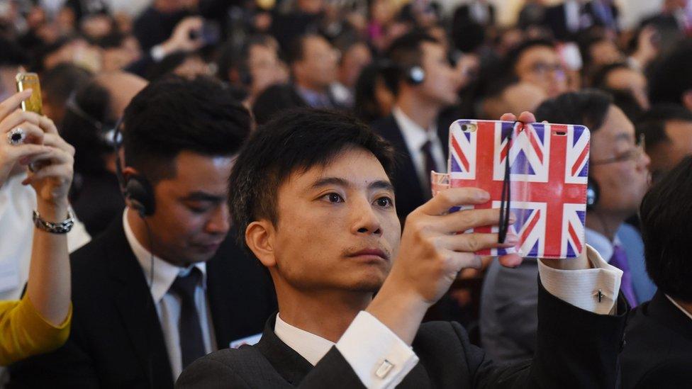 Onlooker holds Union jack phone at Mansion House