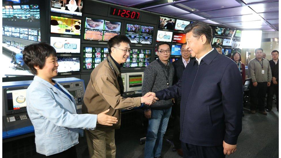 Chinese President Xi Jinping shakes hands with staff members at China Central Television