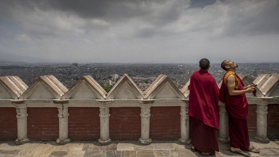 two-monks-standing-together-in-red-and-orange-robes