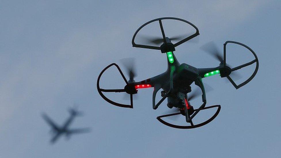 a drone with a plane in the background