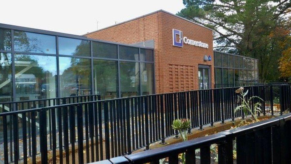 Glass and brick extension with black railing in foreground