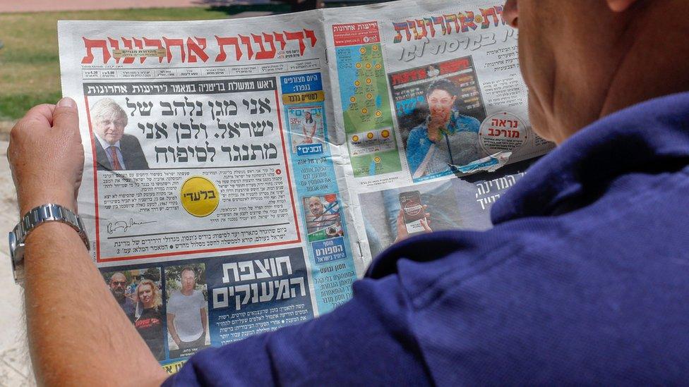 A man looks at an article by Boris Johnson on the front page of the Hebrew-language Israeli newspaper Yedioth Ahronoth (1 July 2020)