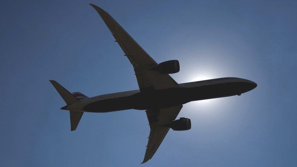 Aircraft silhouetted in sky over Heathrow