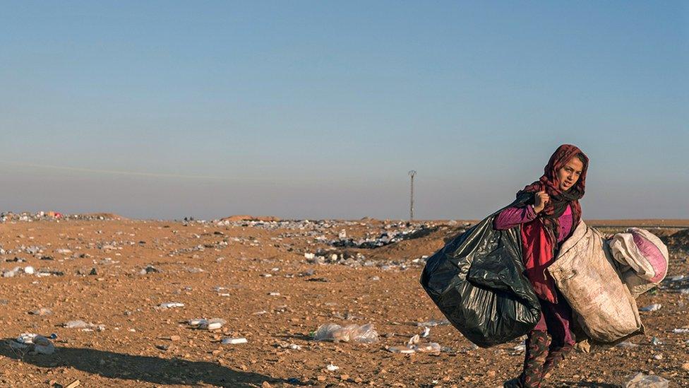 Walaa carrying big plastic bags of rubbish