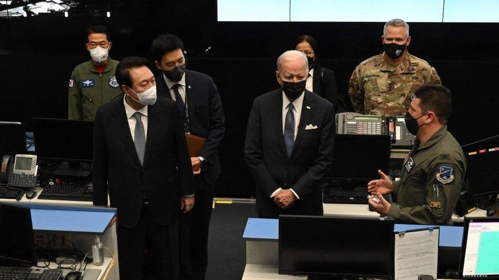 US President Joe Biden (centre R), accompanied by South Korea's President Yoon Suk-yeol (centre L), tours the Air Operations Centers Combat Operations Floor at Osan Air Base in Pyeongtaek on May 22, 2022