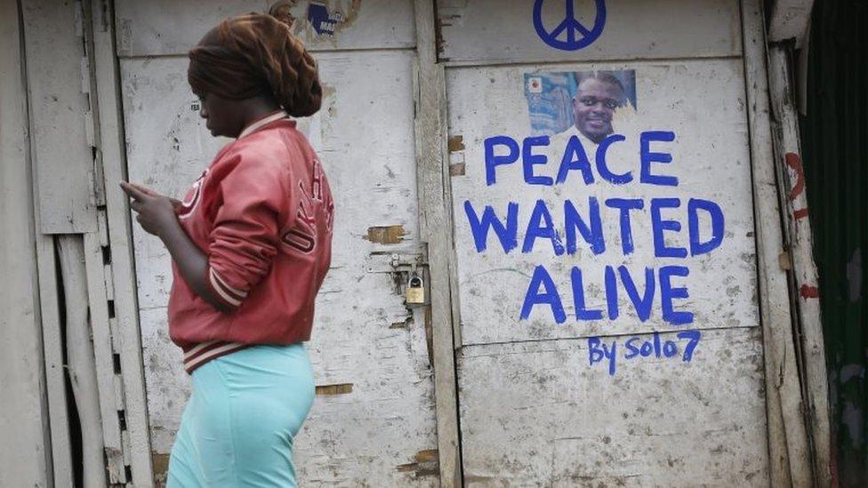 A woman walks past a shop with a message of peace painted recently by local street artist Solomon Muyundo, also known as Solo7, on its door in Kibera slum, one of the opposition leader Raila Odinga"s strongholds in the capital Nairobi, Kenya, 23 July 2017.