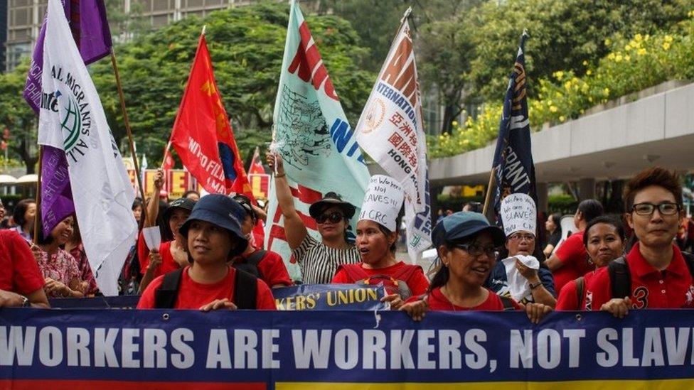 Domestic helpers hold a banner as they take part in a protest in Hong Kong on September 4, 2016
