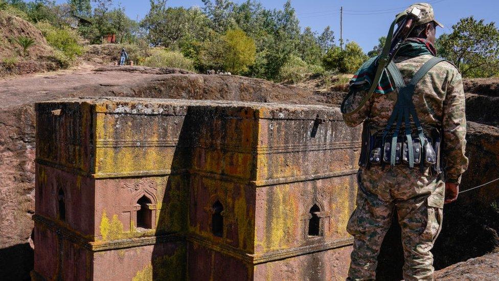 A soldier stands in front of a church