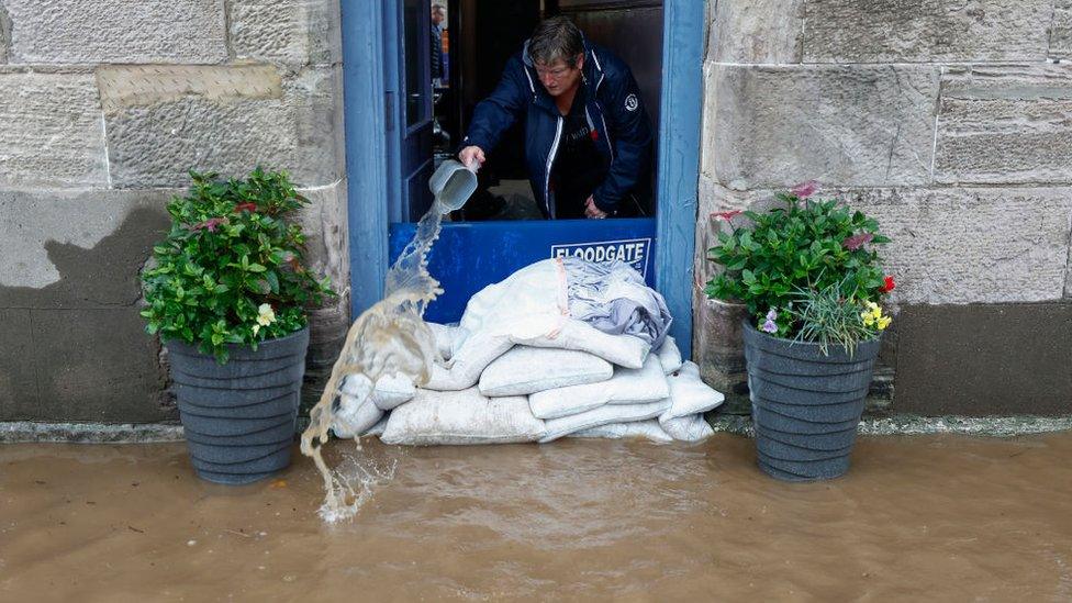 A person pouring water from out of their home