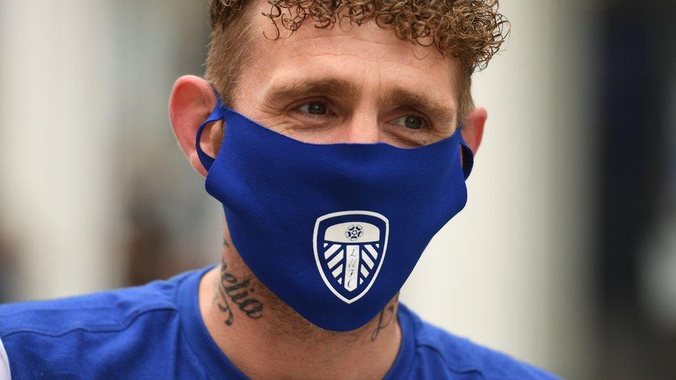 Man wearing Leeds football themed mask