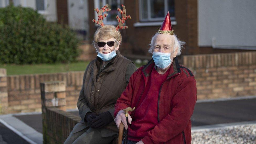 A man and a woman in festive clothing celebrate Christmas Day in Cardiff, Wales