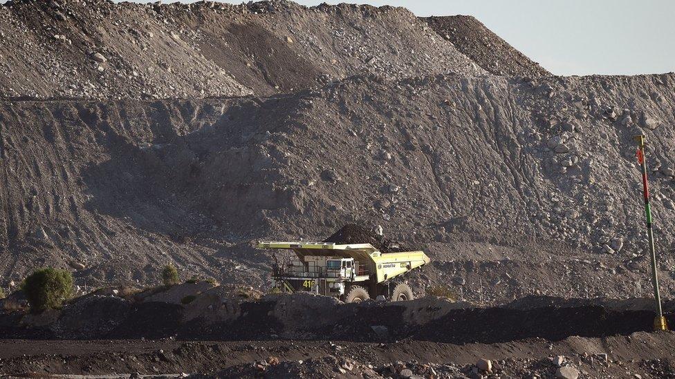 A photo taken on November 18, 2015, shows a large truck driving trough an open-cut coal mine in Singleton in the Hunter Valley north of Sydney as Australia plans to dramatically ramp up coal exports