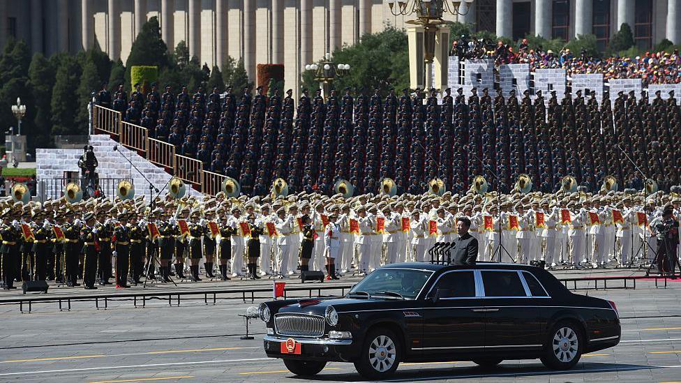 Xi Jinping begins a review of troops from a car during a military parade at Tiananmen Square in Beijing on September 3, 2015
