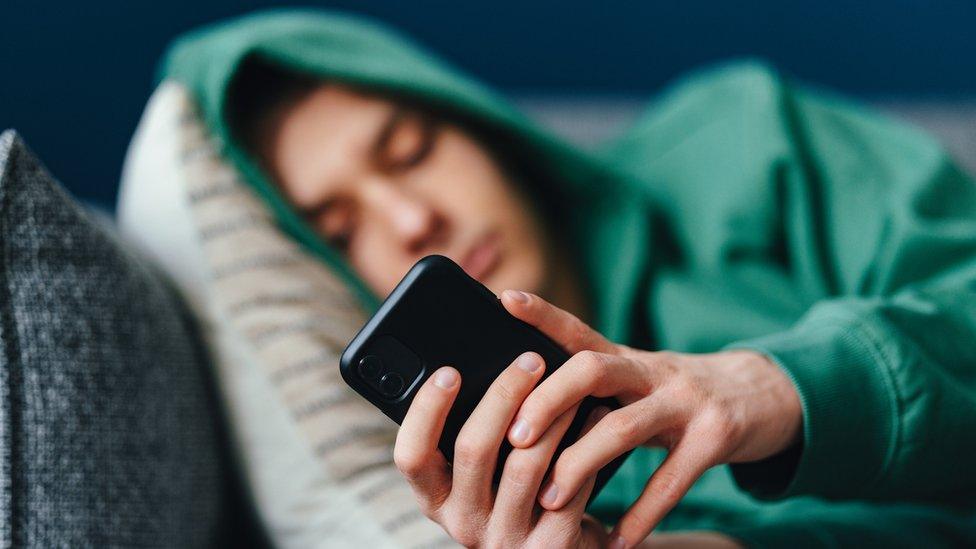 Child on their phone on the sofa