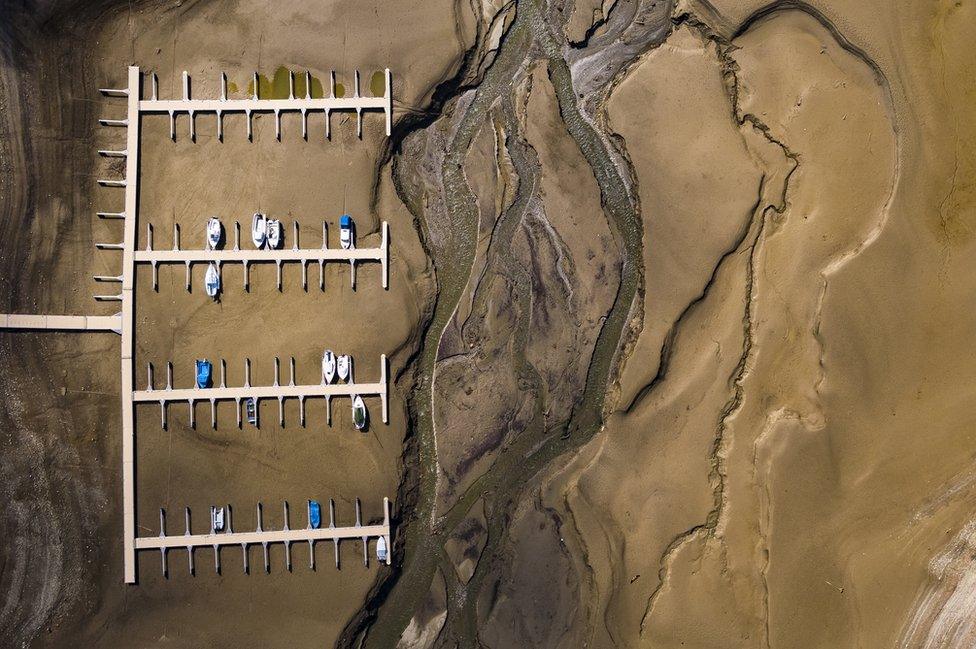 Stranded boats are pictured on the dried out shoes of the Lake of Gruyere.