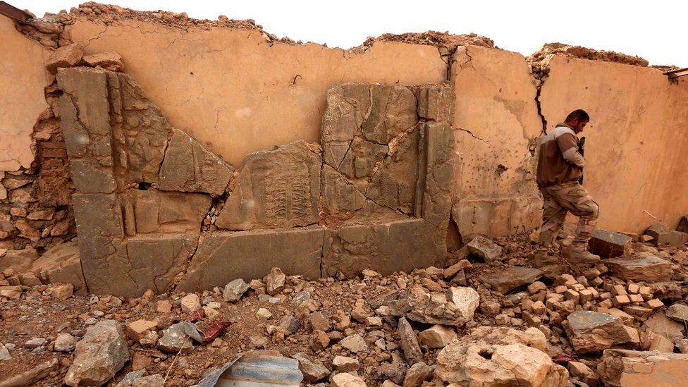 An Iraqi soldier walks past damaged Assyrian artefacts at Nimrud (15 November 2016)