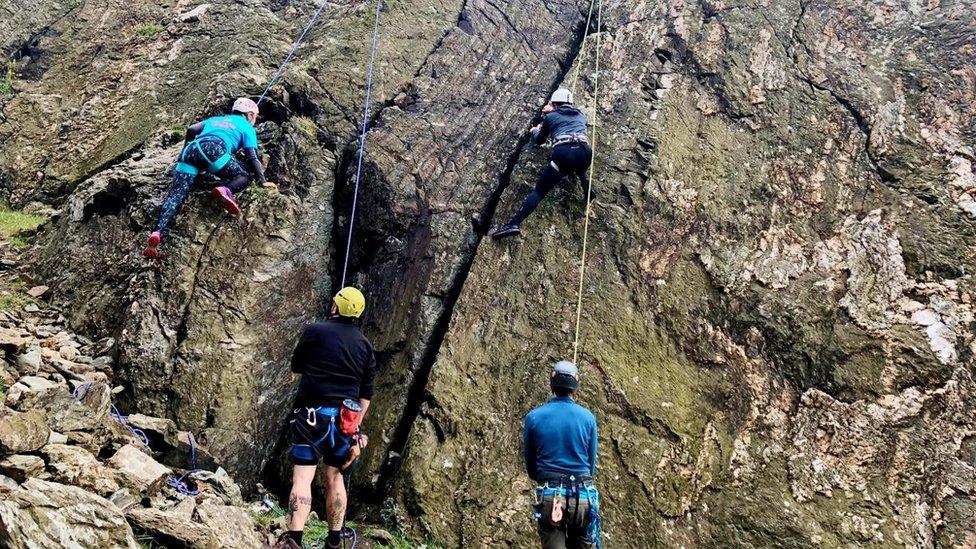 A group of people rock climbing