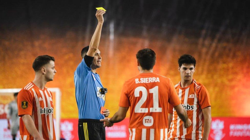 Referee showing a player a yellow card