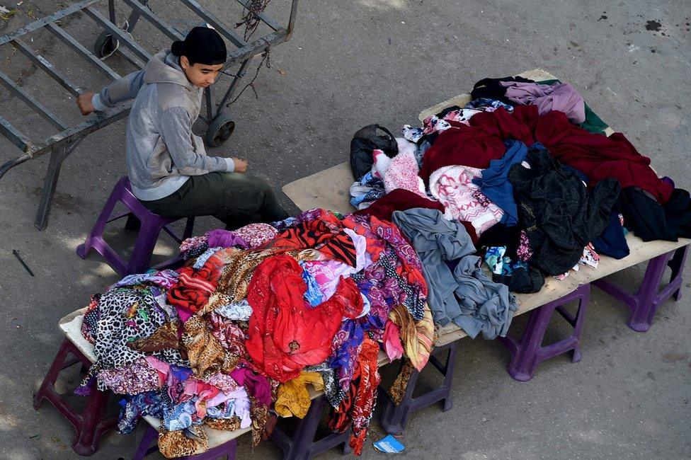 A Tunisian boy sells clothes at a market in the centre of Tunis on April 14, 2017. AFP PHOTO / FETHI BELAIDFETHI