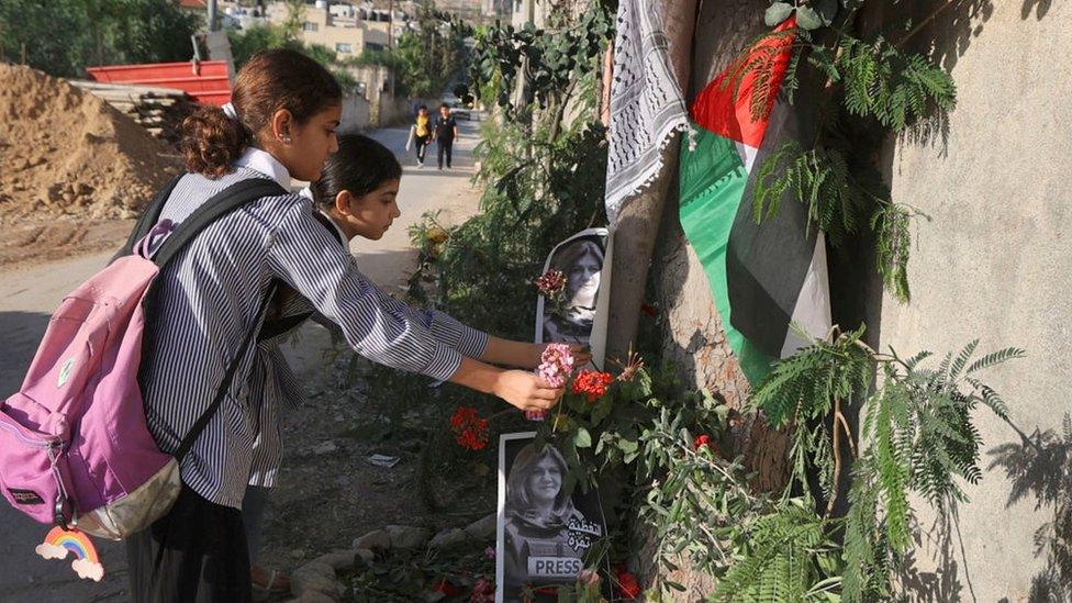 Palestinian schoolgirls lay flowers at the site in Jenin where Shireen Abu Aqla was shot (12 May 2022)