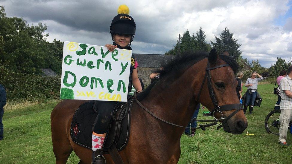 Girl on a horse with a sign