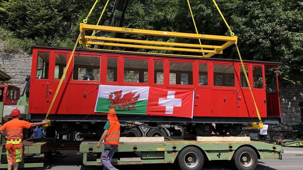 Red steam engine carriage with Swiss and Welsh flags