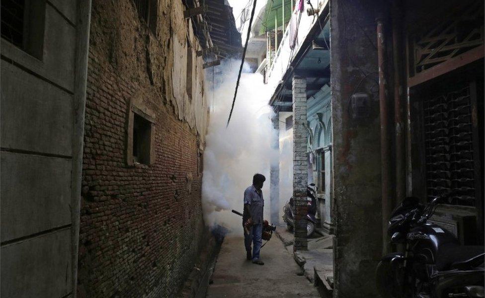 An Indian health worker fumigates an area in order to prevent the spread of mosquito-borne diseases in Allahabad, India, Wednesday, Sept. 14, 2016.