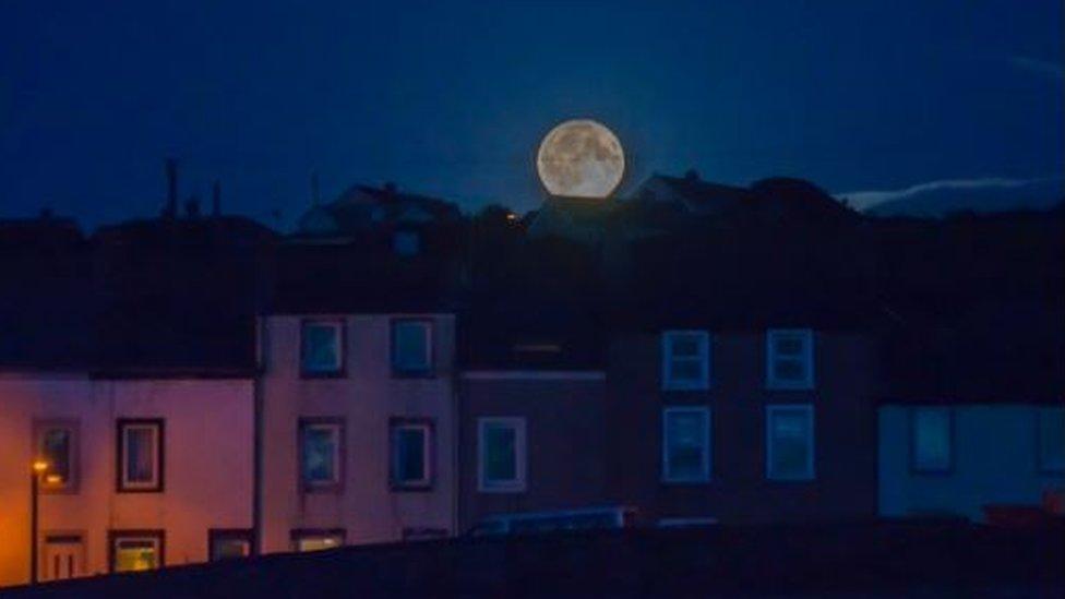 The Harvest Moon rising behind homes in Harrington, West Cumbria, England