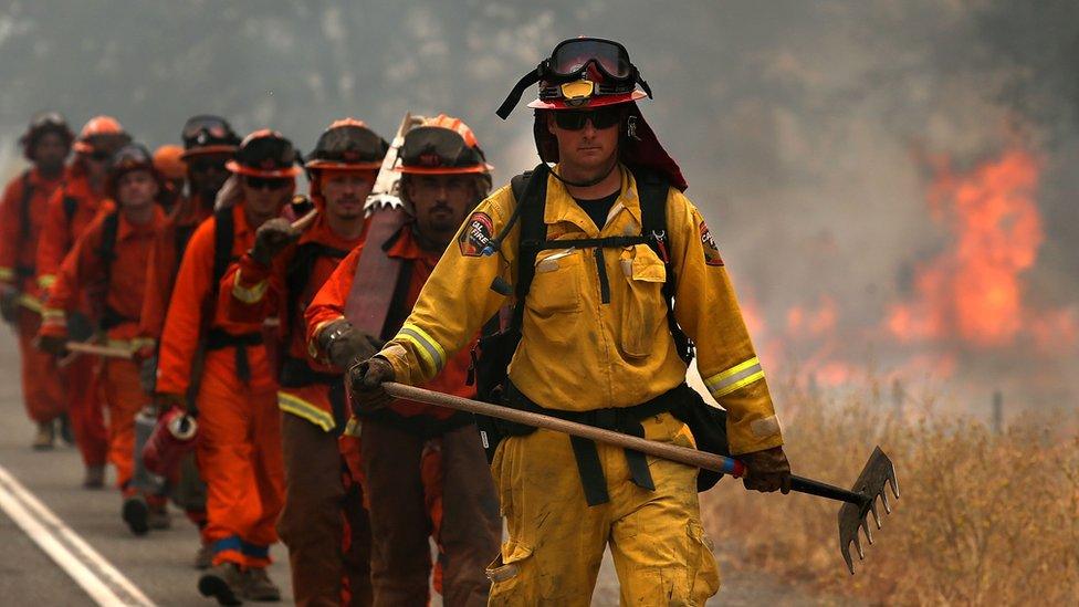 A Cal Fire firefighter leads a group of inmate firefighters in August