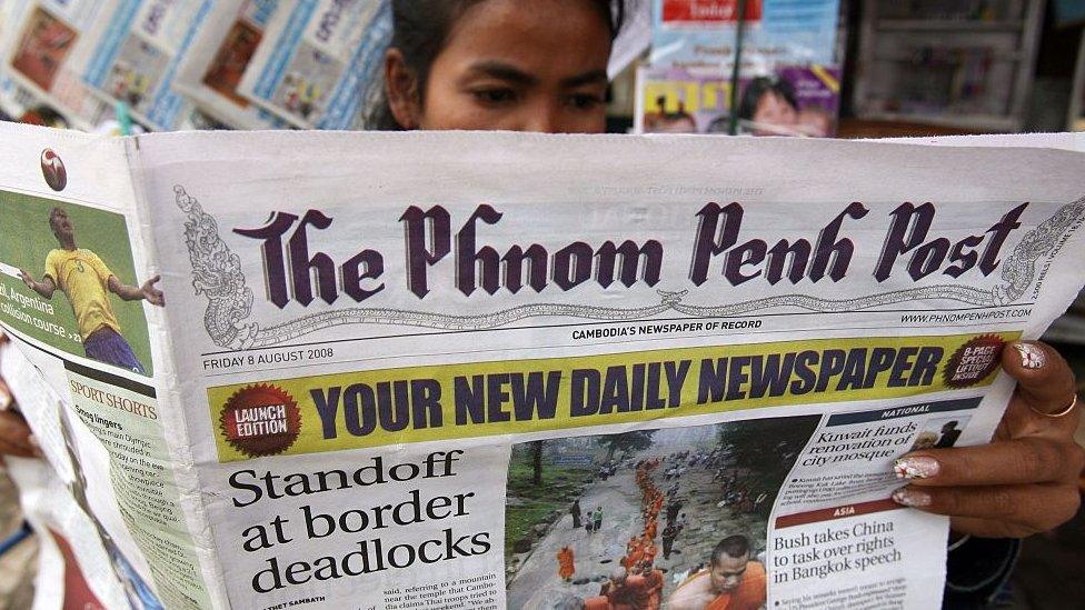 A Cambodian woman reads a copy of the English-language newspaper The Phnom Penh Post at a news stand in Phnom Penh on August 8, 2008.