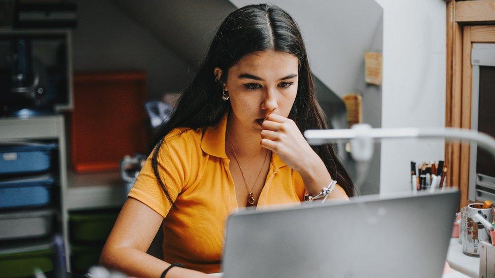 A teenager looking at her computer screen