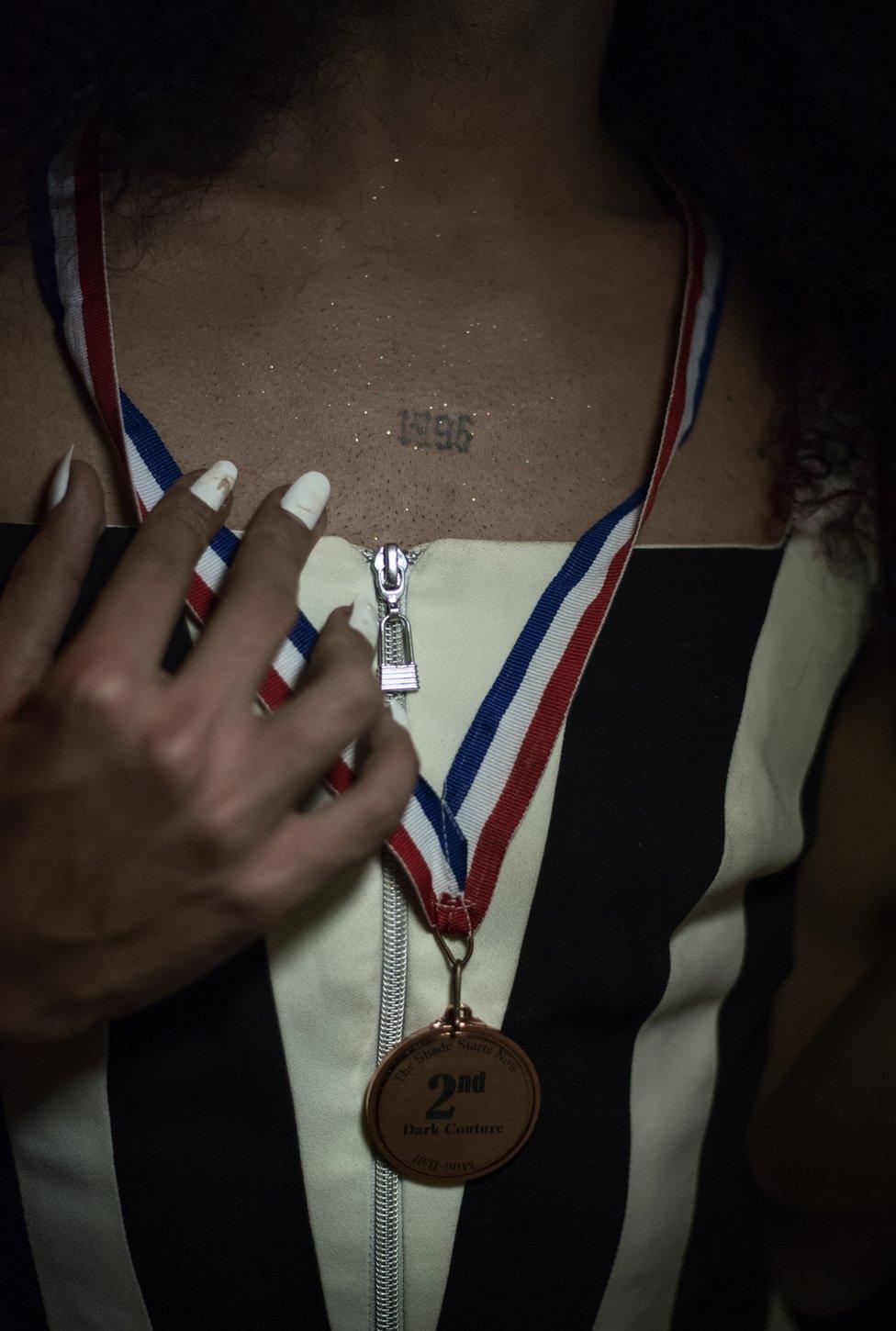 Drag queen Robin Hoes poses with a medal