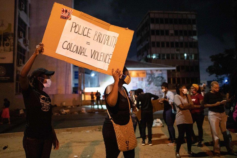 Activists hold a placard in Accra