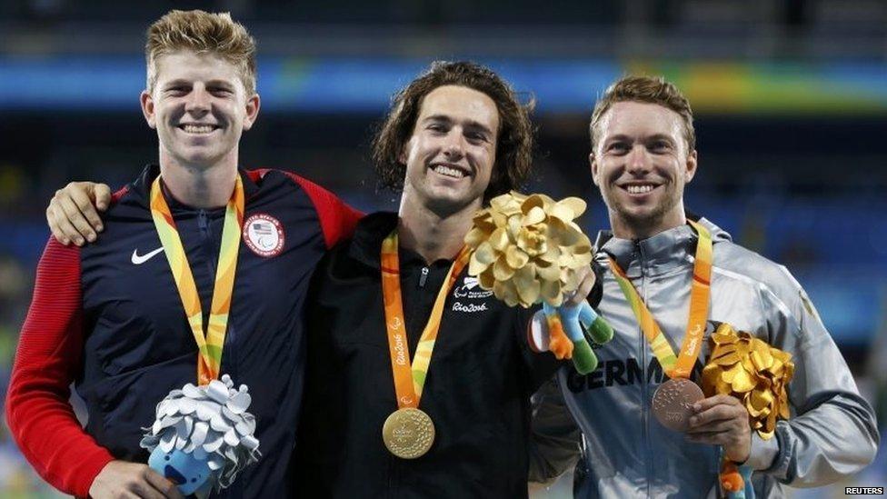 Gold medallist Liam Malone of New Zealand (C) poses with silver medallist Hunter Woodhall of the United States (L) and bronze medallist David Behre of Germany during the victory ceremony.