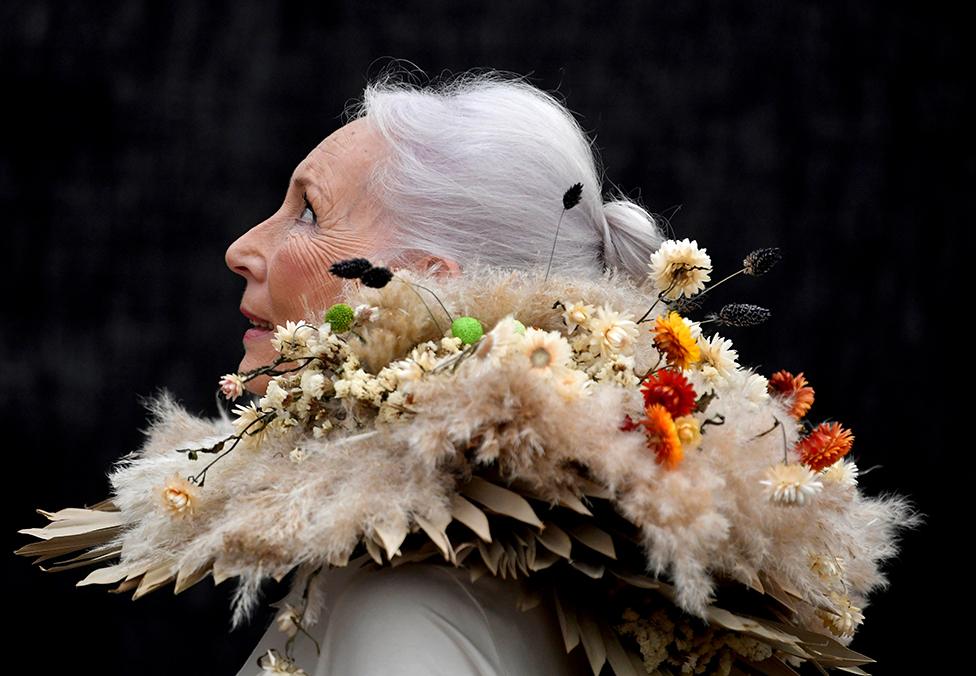 A woman wearing clothing made from dried flowers attends the RHS Chelsea Flower Show in London.