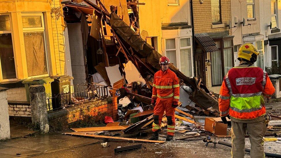 debris and crews after house explosion