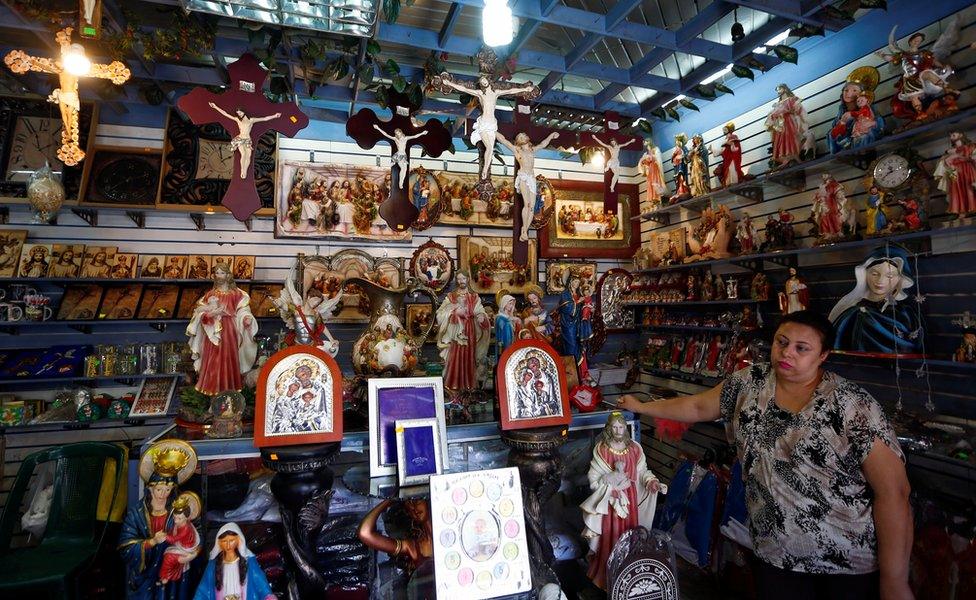 A woman stands inside a Christian souvenir shop