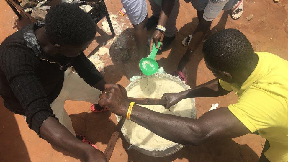 People cooking the semolina in a huge pot