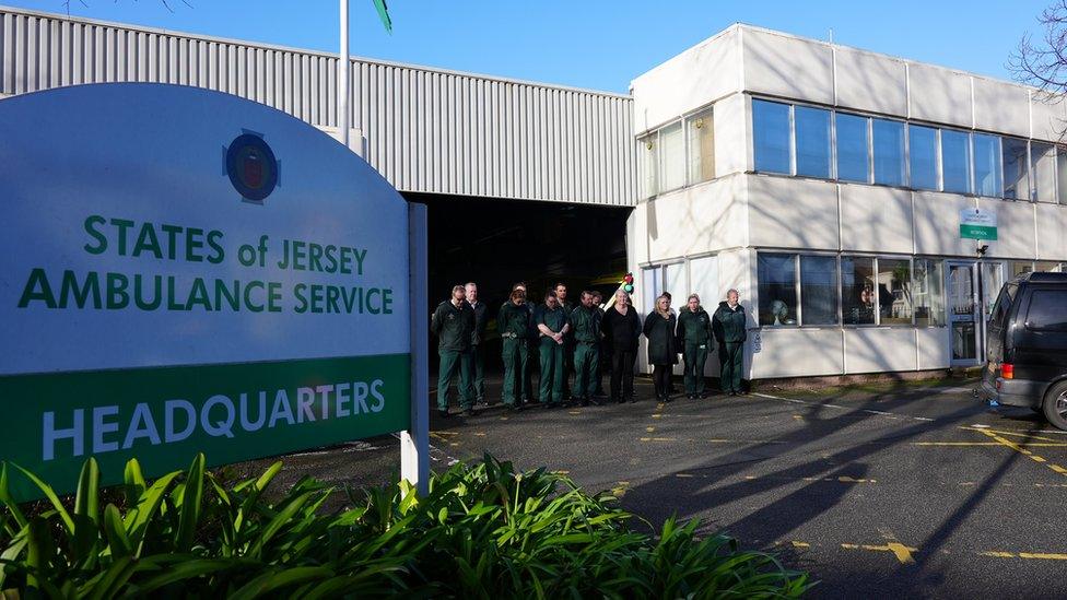 Ambulance service members standing outside building